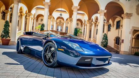 Sleek Blue Sports Car Under Historic Arches wallpaper
