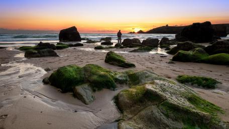 Serene Sunset Over Rocky Beach wallpaper