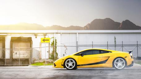 Vibrant Yellow Supercar in Urban Setting wallpaper