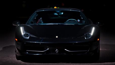Sleek Black Sports Car in Shadowy Setting wallpaper