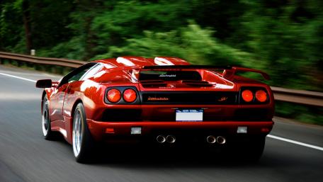 Sleek Red Lamborghini on the Open Road wallpaper
