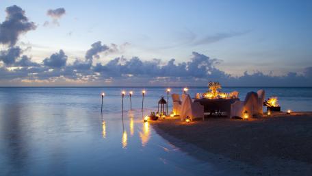 Serene Beachfront Candlelit Dinner Setup wallpaper