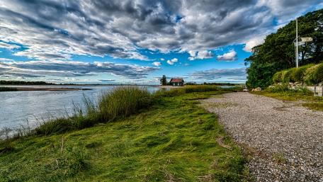 Tranquil Waterside Landscape with Dramatic Clouds wallpaper