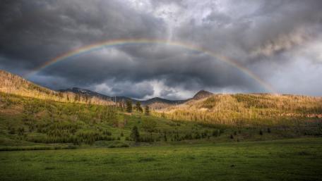 Vibrant Rainbow Over Majestic Mountains wallpaper