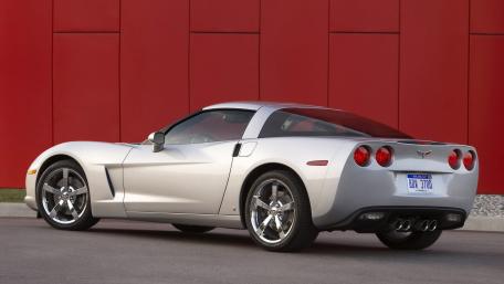 Sleek Silver Corvette Against a Bold Red Backdrop wallpaper