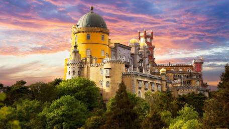Majestic Castle Amidst Vibrant Sunset Sky wallpaper