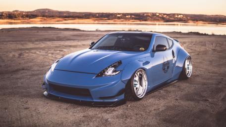 Sleek Blue Sports Car on a Scenic Shoreline wallpaper