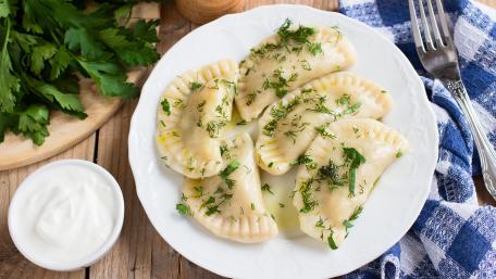 Delicious Homemade Dumplings on a Plate with Herbs and Sauce wallpaper