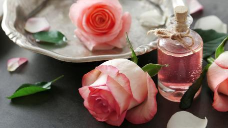 Elegant Roses and Fragrance Bottle in Soft Colors wallpaper