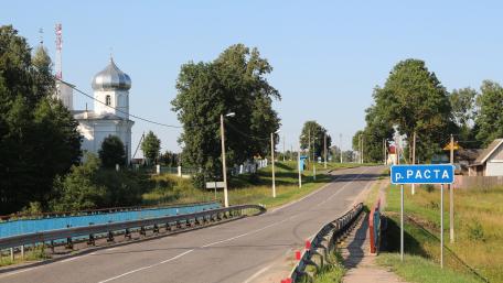 Peaceful Town Road Surrounded by Nature and Architecture wallpaper