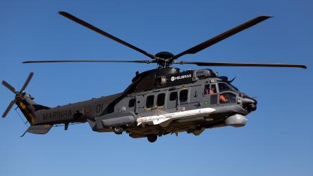 Military Helicopter in Majestic Flight over Clear Sky wallpaper
