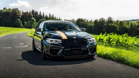 Sleek BMW M5 Driving on Open Road in Nature wallpaper