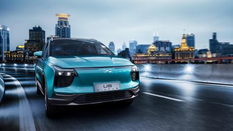 Sleek Electric Vehicle in Urban Landscape at Night wallpaper