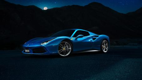 Sleek Blue Sports Car Under Moonlit Sky wallpaper