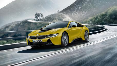 Sleek Yellow BMW Driving on Scenic Roadway wallpaper