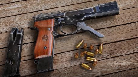Classic Handgun with Ammunition on Wooden Surface wallpaper