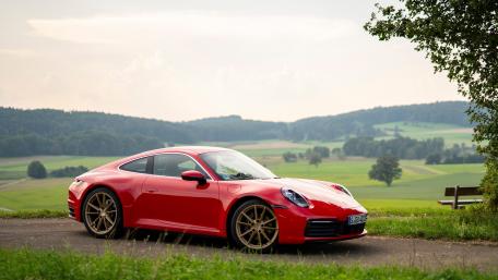 Sleek Red Sports Car on Scenic Countryside Road wallpaper