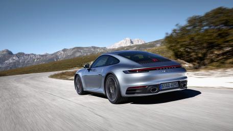 Sleek Silver Sports Car Driving Through Serene Landscape wallpaper