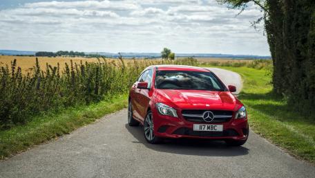 Vibrant Red Car on a Scenic Roadway wallpaper