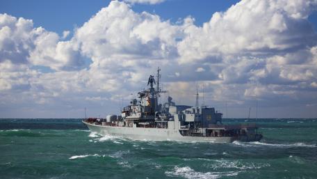 Majestic Naval Ship Sailing Through Vibrant Waves wallpaper