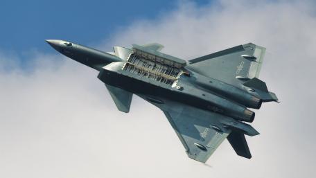 Sleek Military Jet in Action Above Clouds wallpaper