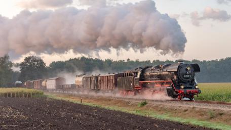 Steam Engine in Motion Amidst a Misty Landscape wallpaper