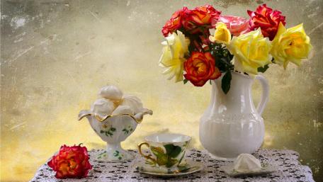 Charming Floral Arrangement with Delicate Teacup and Sweet Treats wallpaper