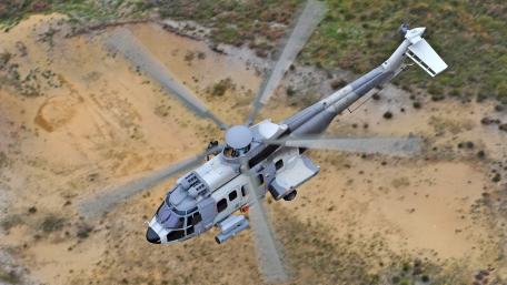 Helicopter in Motion Over Desert Landscape wallpaper