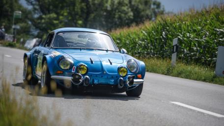 Classic Blue Sports Car in Motion on a Scenic Roadway wallpaper