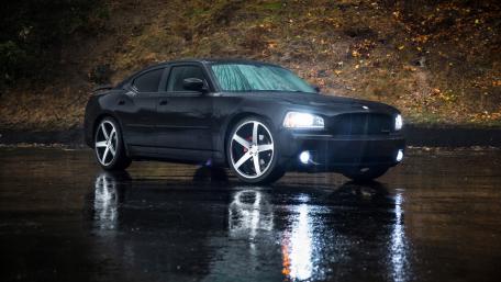 Sleek Black Car in Rainy Setting wallpaper