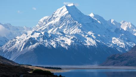 Majestic Snow-Capped Peaks Under Clear Blue Skies wallpaper