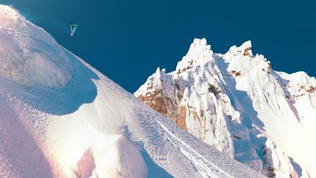 Thrilling Snowboard Adventure in Majestic Mountains wallpaper