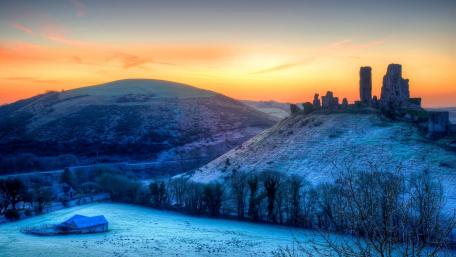 Serene Sunrise Over Ruins and Fields wallpaper