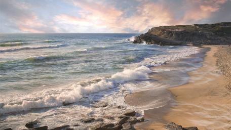 Serene Beach Landscape with Gentle Waves and Soft Clouds wallpaper