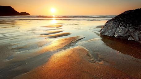 Golden Sunset Over Serene Beach Waves wallpaper