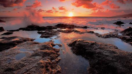 Vibrant Sunset Over Rocky Shoreline wallpaper