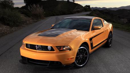 Bold Orange Mustang on a Scenic Roadway wallpaper