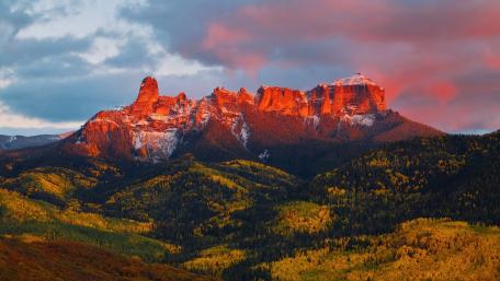 Majestic Mountain Sunset View Amidst Vibrant Forests wallpaper