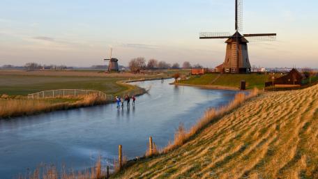 Serene Dutch Landscape with Windmills and Skaters wallpaper