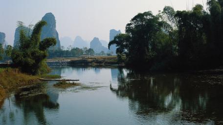Serene River Amidst Majestic Mountains wallpaper