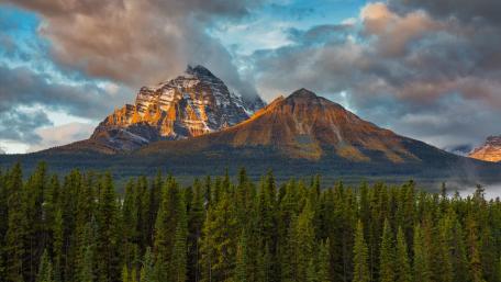 Majestic Mountain Sunrise Over Forest Retreat wallpaper