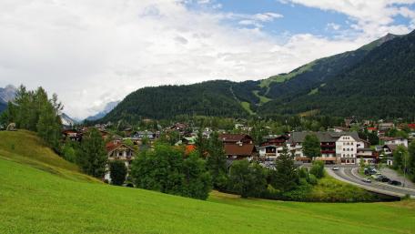 Lush Green Cityscape Under Cloudy Skies wallpaper