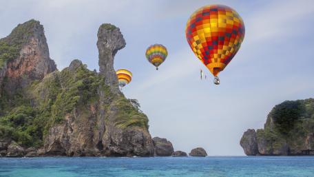 Colorful Balloons Over Scenic Coastline wallpaper