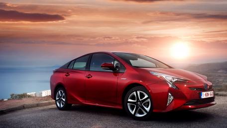 Sleek Red Car Against Sunset Scenery wallpaper