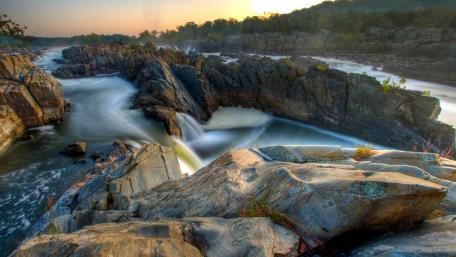Majestic River Flowing Through Rocky Landscape wallpaper