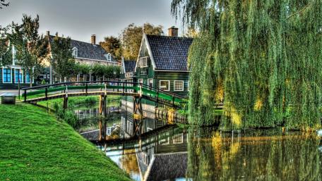 Charming Riverfront Bridge in Serene Cityscape wallpaper