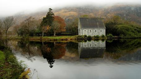 Serene Reflection of St Finbarr Oratory in Ireland’s Gougane Barra wallpaper