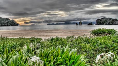 Serene Beach Landscape Under Dramatic Skies wallpaper