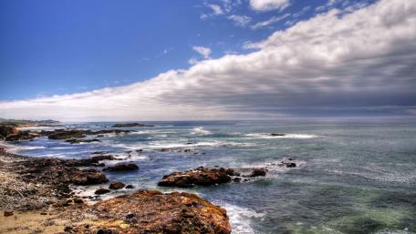 Serene Coastal Landscape Under Dramatic Clouds wallpaper