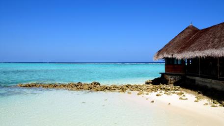 Serene Beachfront Paradise Amidst Calm Waters wallpaper